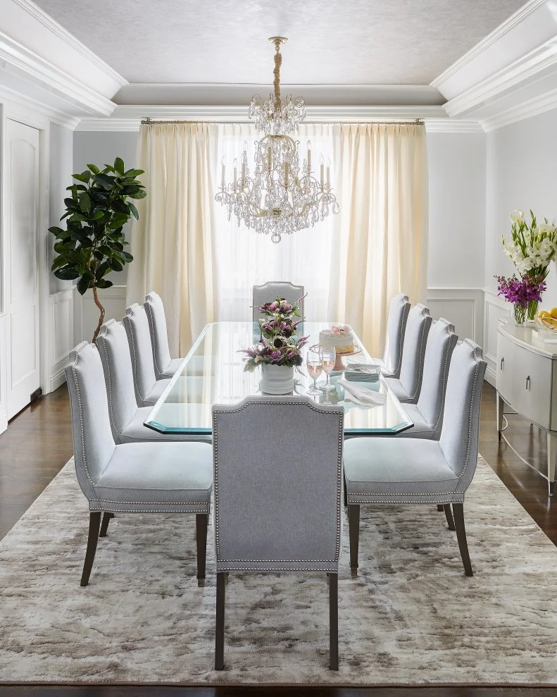 Formal dining room with chandelier, layered ceiling detail, and crown molding